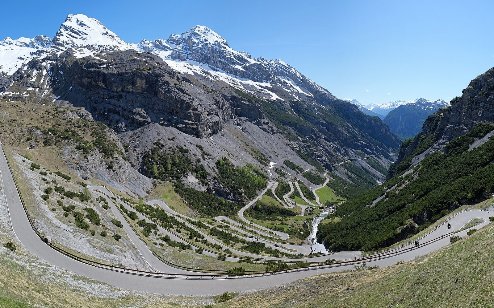 A mountain road of stacked hairpins climbing a bare slope